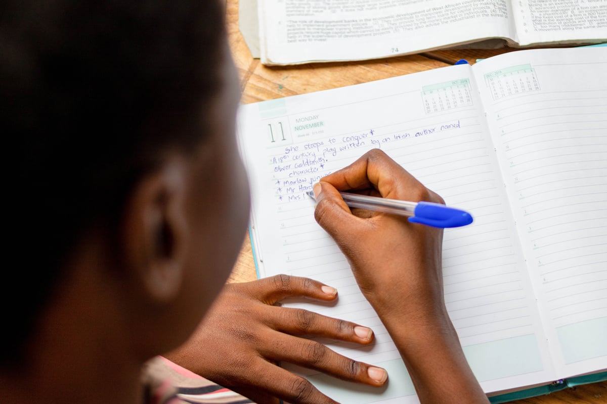 Student Writing on Notebook